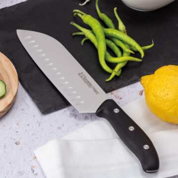 Cuchillo santoku alveolado de 18 cm 3 Claveles Domvs 957 en la tabla de corte – Cuchillalia.com